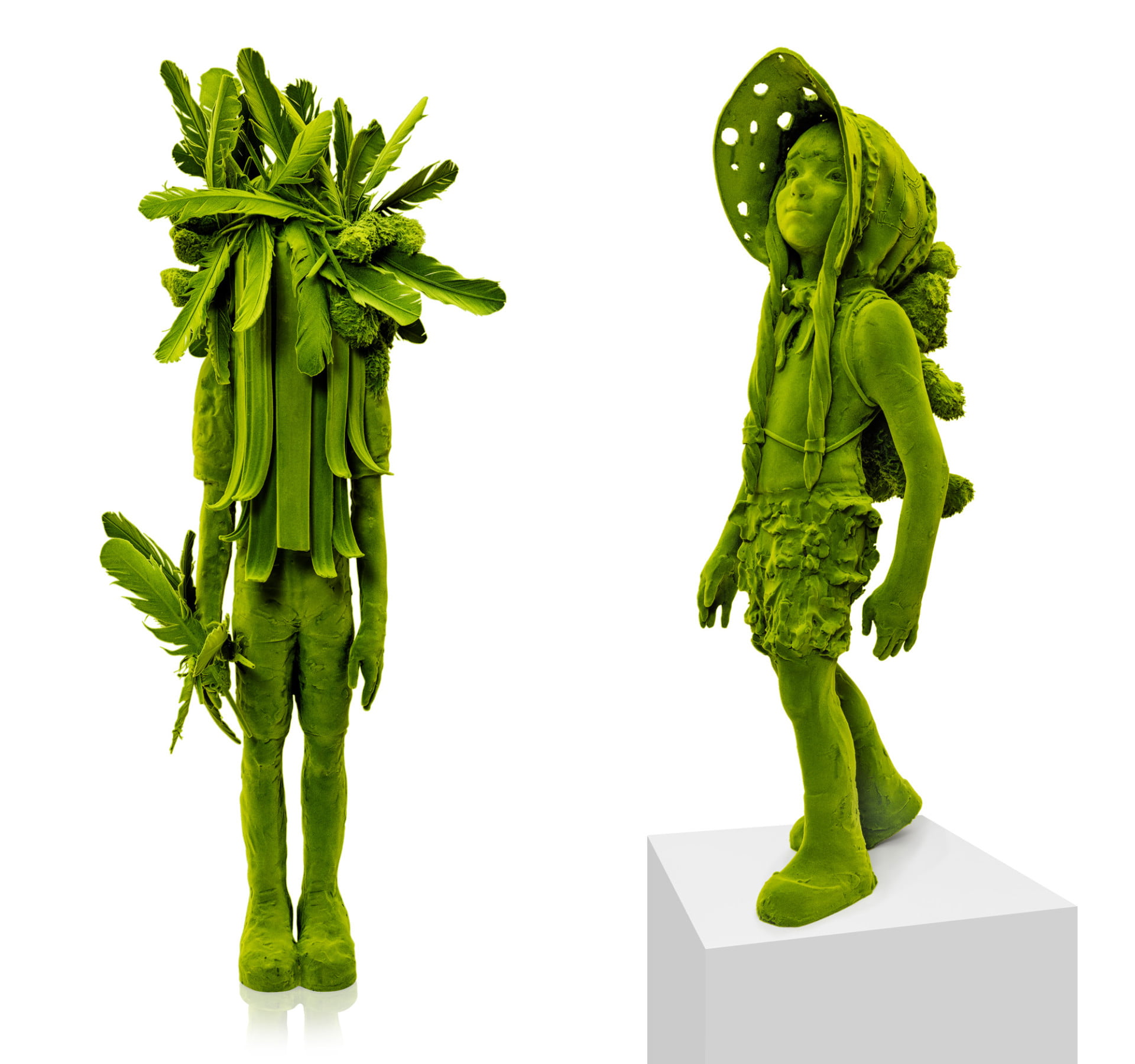 Two ceramid sculptures of young figures that are coated in green flocking so that they appear to be coated in moss. Uma tem penas e uma barba comprida a obscurecer o seu rosto; a outra usa uma touca e um brinquedo de pelúcia nas costas.
